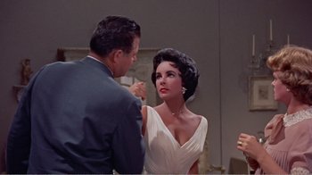 Movie still from “Cat on a Hot Tin Roof” (1958), directed by Richard Brooks – A man and a woman in formal wear talking to each other; Medium shot, Over the shoulder angle