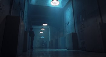 Movie still from “Catch Me If You Can” (2002), directed by Steven Spielberg – A person is standing in a dark hallway; Extreme Wide shot, Low angle