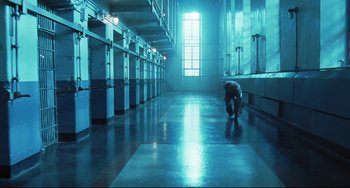 Movie still from “Catch Me If You Can” (2002), directed by Steven Spielberg – A man is bending down in a room; Wide shot, High angle