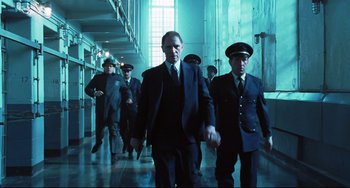 Movie still from “Catch Me If You Can” (2002), directed by Steven Spielberg – A group of men walking down a hall way; Wide shot, Low angle