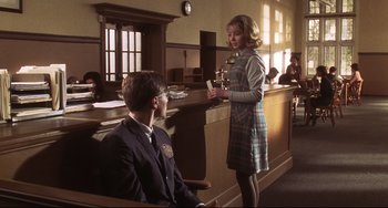 Movie still from “Catch Me If You Can” (2002), directed by Steven Spielberg – A young man and a young woman are in a courtroom; Medium shot, Low angle
