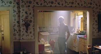 Movie still from “Catch Me If You Can” (2002), directed by Steven Spielberg – A man standing in the doorway of a kitchen; Wide shot, Low angle
