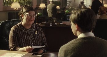 Movie still from “Catch Me If You Can” (2002), directed by Steven Spielberg – A woman is talking to a man at a table; Medium shot, Over the shoulder angle