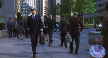 Movie still from “Catch Me If You Can” (2002), directed by Steven Spielberg – A group of people walking down a street; Wide shot, Low angle