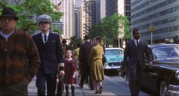Movie still from “Catch Me If You Can” (2002), directed by Steven Spielberg – A group of people walking down a street; Wide shot, Low angle