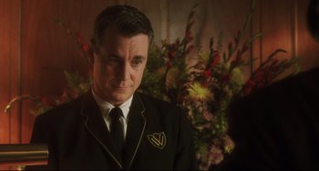 Movie still from “Catch Me If You Can” (2002), directed by Steven Spielberg – A person wearing a suit and tie; Close Up shot, Low angle