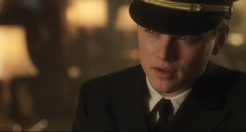 Movie still from “Catch Me If You Can” (2002), directed by Steven Spielberg – A man in a suit and tie wearing a hat; Close Up shot, Over the shoulder angle