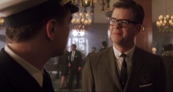 Movie still from “Catch Me If You Can” (2002), directed by Steven Spielberg – A man wearing a suit and tie talking to another man wearing a suit and tie; Close Up shot, Over the shoulder angle