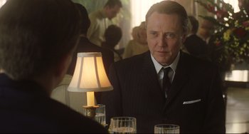 Movie still from “Catch Me If You Can” (2002), directed by Steven Spielberg – A man wearing a suit and tie in front of a mirror; Close Up shot, Over the shoulder angle