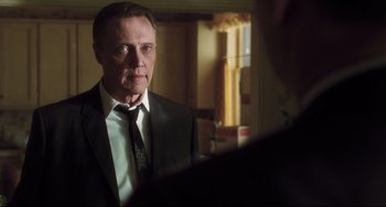 Movie still from “Catch Me If You Can” (2002), directed by Steven Spielberg – A man wearing a suit and tie looking at a mirror; Close Up shot, Over the shoulder angle