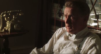 Movie still from “Catch Me If You Can” (2002), directed by Steven Spielberg – An older man wearing a white shirt and a bow tie; Close Up shot, Low angle
