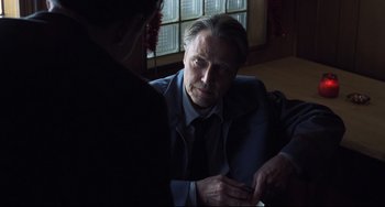 Movie still from “Catch Me If You Can” (2002), directed by Steven Spielberg – An older man wearing a suit and tie talking to a younger man; Close Up shot, Over the shoulder angle