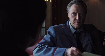 Movie still from “Catch Me If You Can” (2002), directed by Steven Spielberg – An older man sitting in front of another man in a suit; Close Up shot, Over the shoulder angle