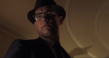 Movie still from “Catch Me If You Can” (2002), directed by Steven Spielberg – A person wearing a hat and glasses; Close Up shot, Low angle