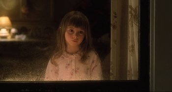 Movie still from “Catch Me If You Can” (2002), directed by Steven Spielberg – A little girl looking out a window in a pink dress; Close Up shot, Over the shoulder angle