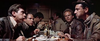 Movie still from “Catch-22” (1970), directed by Mike Nichols – A group of men sitting at a dinner table; Close Up shot, Low angle