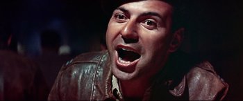 Movie still from “Catch-22” (1970), directed by Mike Nichols – A person wearing a jacket and hat; Close Up shot, Low angle