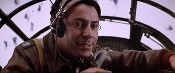 Movie still from “Catch-22” (1970), directed by Mike Nichols – A person wearing headphones and holding an object; Close Up shot, Low angle