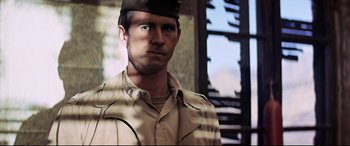 Movie still from “Catch-22” (1970), directed by Mike Nichols – A man in a military uniform is standing in front of a window; Close Up shot, Over the shoulder angle