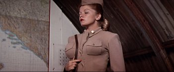 Movie still from “Catch-22” (1970), directed by Mike Nichols – A woman dressed in a military uniform holding a leather strap; Medium shot, Low angle