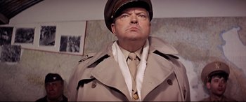 Movie still from “Catch-22” (1970), directed by Mike Nichols – A man in a military uniform is looking at the camera; Close Up shot, Low angle