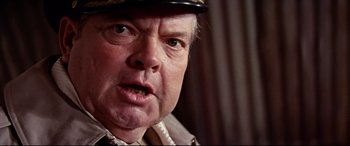 Movie still from “Catch-22” (1970), directed by Mike Nichols – An older man wearing a military uniform and a hat; Close Up shot, Low angle