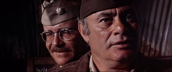Movie still from “Catch-22” (1970), directed by Mike Nichols – A couple of men standing next to each other in uniform; Close Up shot, Low angle