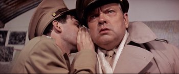 Movie still from “Catch-22” (1970), directed by Mike Nichols – A man in a uniform and a man in a hat; Close Up shot, Over the shoulder angle