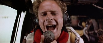 Movie still from “Catch-22” (1970), directed by Mike Nichols – A man wearing headphones and holding a microphone; Close Up shot, Low angle