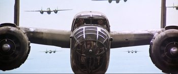 Movie still from “Catch-22” (1970), directed by Mike Nichols – A group of people in a propeller plane flying in the sky; Wide shot, Low angle