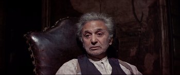 Movie still from “Catch-22” (1970), directed by Mike Nichols – An older man with a gray beard and a mustache; Close Up shot, Low angle