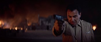 Movie still from “Catch-22” (1970), directed by Mike Nichols – A man is pointing a gun at the camera; Close Up shot, Low angle