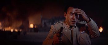 Movie still from “Catch-22” (1970), directed by Mike Nichols – A man holding a gun in his hand and wearing a uniform; Close Up shot, Low angle