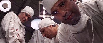Movie still from “Catch-22” (1970), directed by Mike Nichols – A group of surgeons in white hats and white gowns; Close Up shot, Low angle