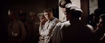 Movie still from “Catch-22” (1970), directed by Mike Nichols – A group of men standing next to each other in uniform; Medium shot, Over the shoulder angle
