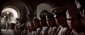 Movie still from “Catch-22” (1970), directed by Mike Nichols – A group of men standing next to each other in uniform; Medium shot, Low angle