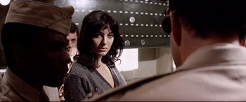 Movie still from “Catch-22” (1970), directed by Mike Nichols – A woman standing in front of two men in front of a mirror; Close Up shot, Over the shoulder angle