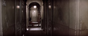 Movie still from “Catch-22” (1970), directed by Mike Nichols – A man and a woman are sitting in a hallway; Wide shot, High angle
