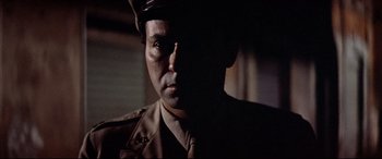 Movie still from “Catch-22” (1970), directed by Mike Nichols – A man wearing a military uniform and a hat; Close Up shot, Low angle