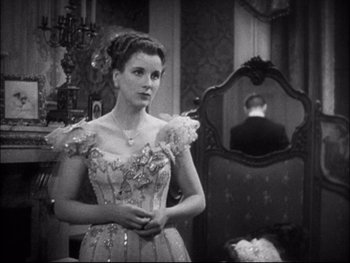 Movie still from “Cavalcade” (1933), directed by Frank Lloyd – An old photo of a woman in a dress; Medium shot, Over the shoulder angle