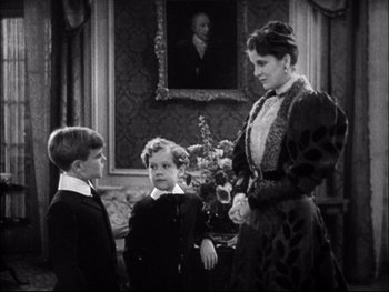 Movie still from “Cavalcade” (1933), directed by Frank Lloyd – A woman standing next to two young boys; Medium shot, High angle