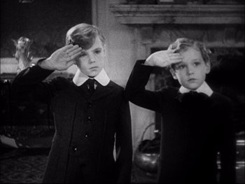 Movie still from “Cavalcade” (1933), directed by Frank Lloyd – Two young boys saluting in front of a fireplace; Medium shot, Low angle