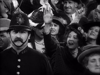 Movie still from “Cavalcade” (1933), directed by Frank Lloyd – A group of people wearing hats and waving at the camera; Close Up shot, High angle