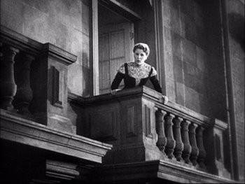Movie still from “Cavalcade” (1933), directed by Frank Lloyd – An old photo of a woman standing on a balcony; Wide shot, Low angle