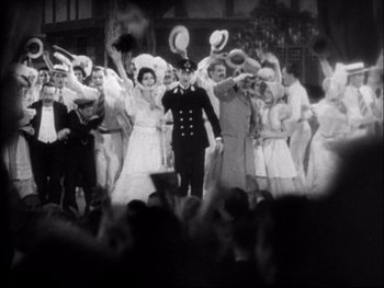 Movie still from “Cavalcade” (1933), directed by Frank Lloyd – A black and white photo of a group of people in costumes; Wide shot, High angle