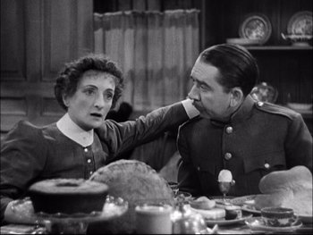 Movie still from “Cavalcade” (1933), directed by Frank Lloyd – An old photo of a man and a woman sitting at a dinner table; Medium shot, High angle