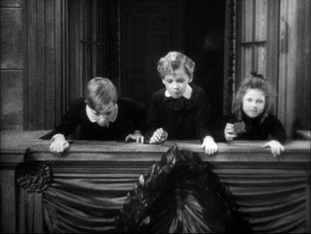 Movie still from “Cavalcade” (1933), directed by Frank Lloyd – Three young children looking out of a window; Medium shot, High angle