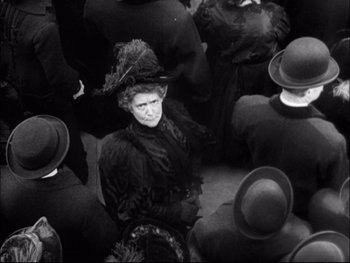 Movie still from “Cavalcade” (1933), directed by Frank Lloyd – An old woman in a crowd of people; Medium shot, High angle