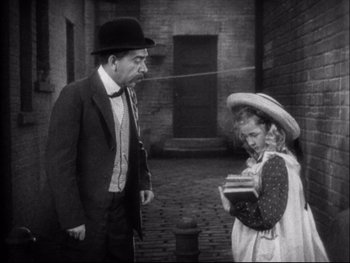 Movie still from “Cavalcade” (1933), directed by Frank Lloyd – An older man and a young girl are talking; Medium shot, High angle