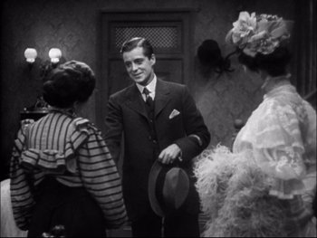 Movie still from “Cavalcade” (1933), directed by Frank Lloyd – A black and white photo of a man in a suit; Medium shot, Over the shoulder angle